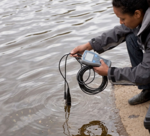 Technicien réalisant une mesure du potentiel redox dans l’eau avec un instrument portable.