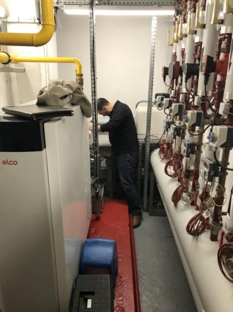 Intervention d'un plombier dans un local technique après une analyse de l'eau.